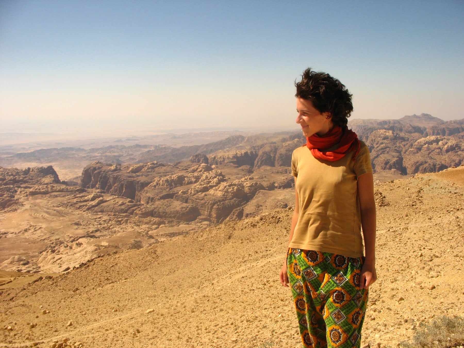 Nora Schweitzer, foulard rouge autour du cou, devant un vaste paysage de canyons désertiques.